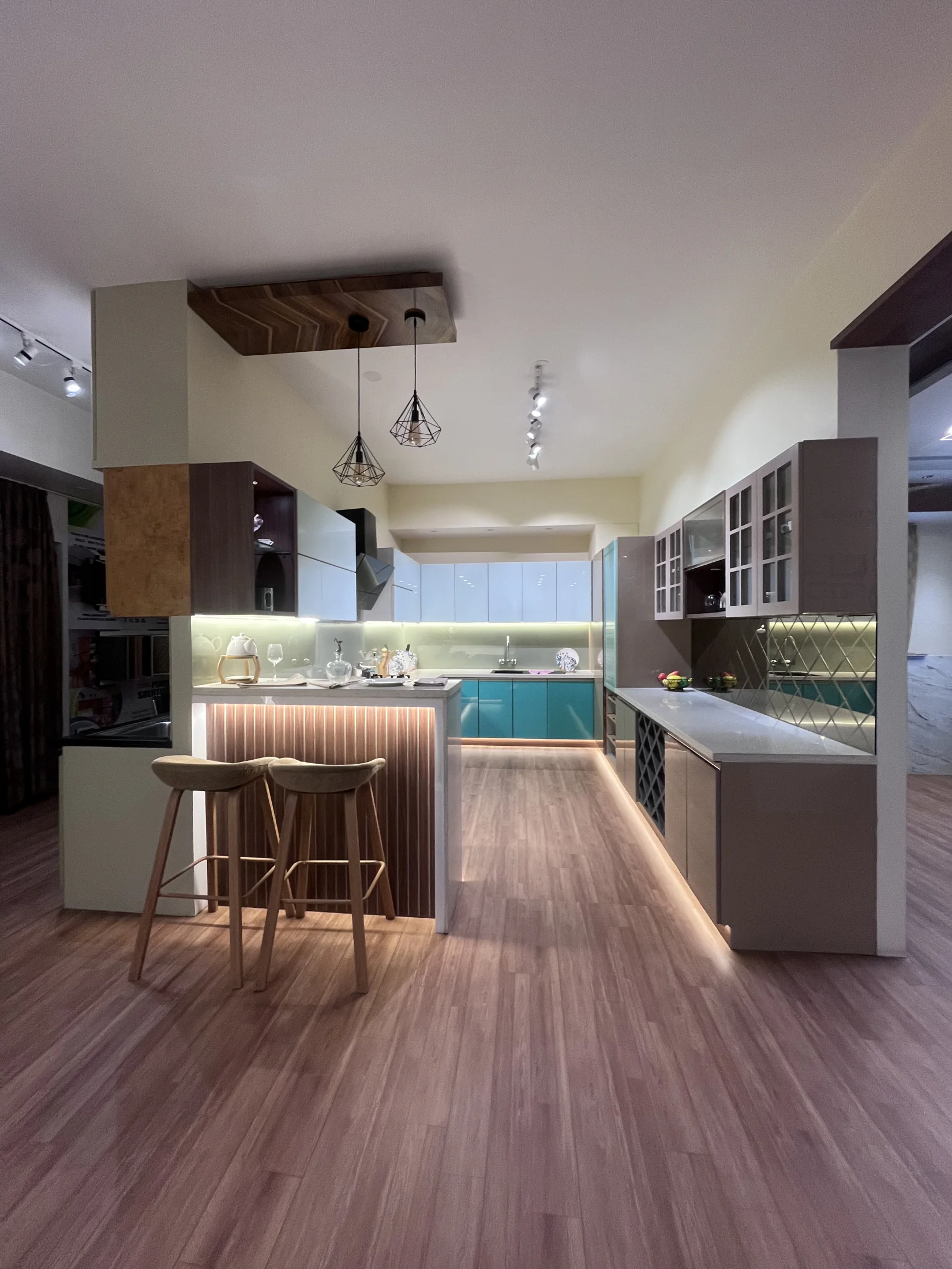 Full view of a teal and grey kitchen by SK Spaces