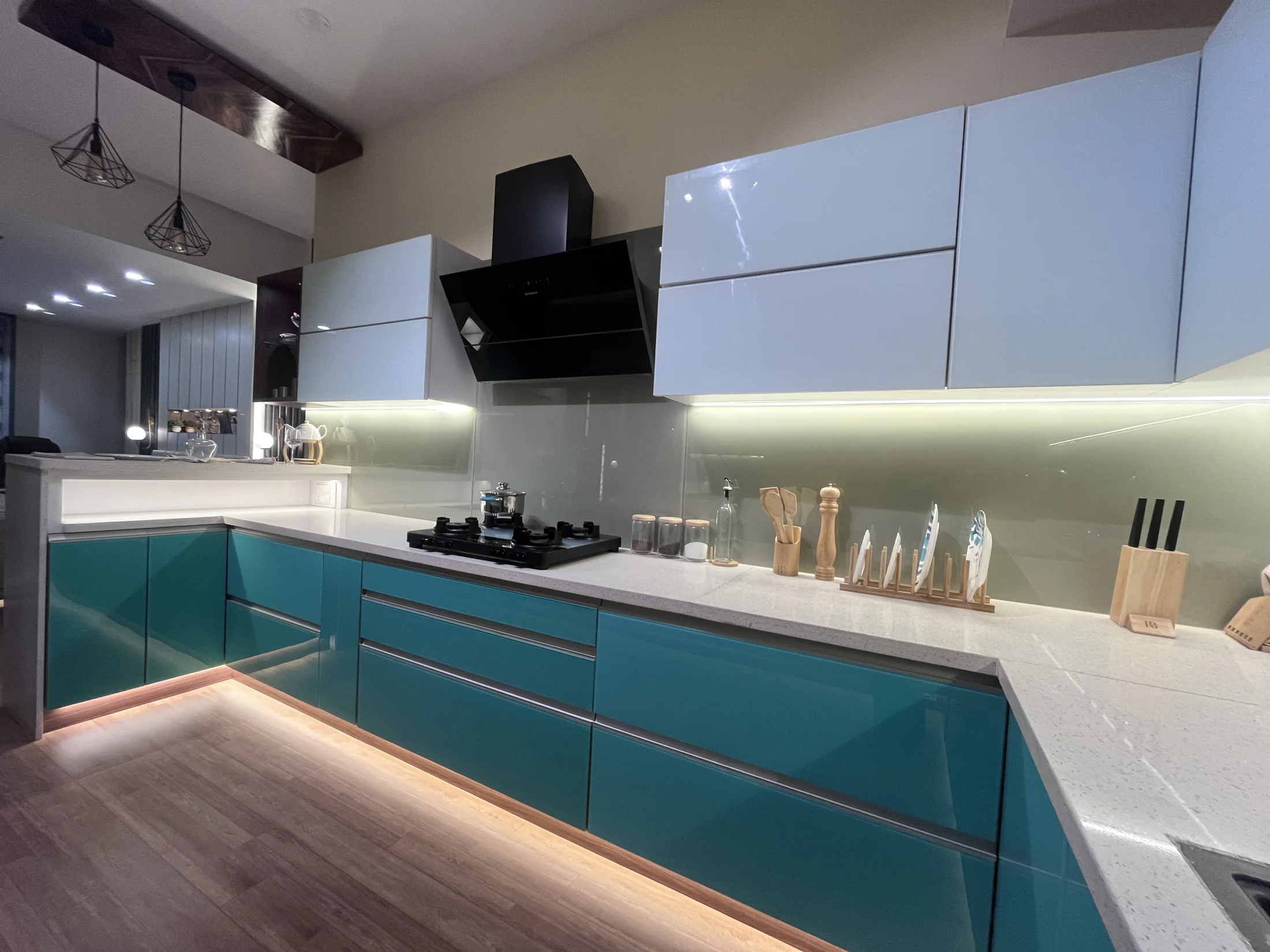 Teal and grey modular kitchen with integrated lighting by SK Spaces