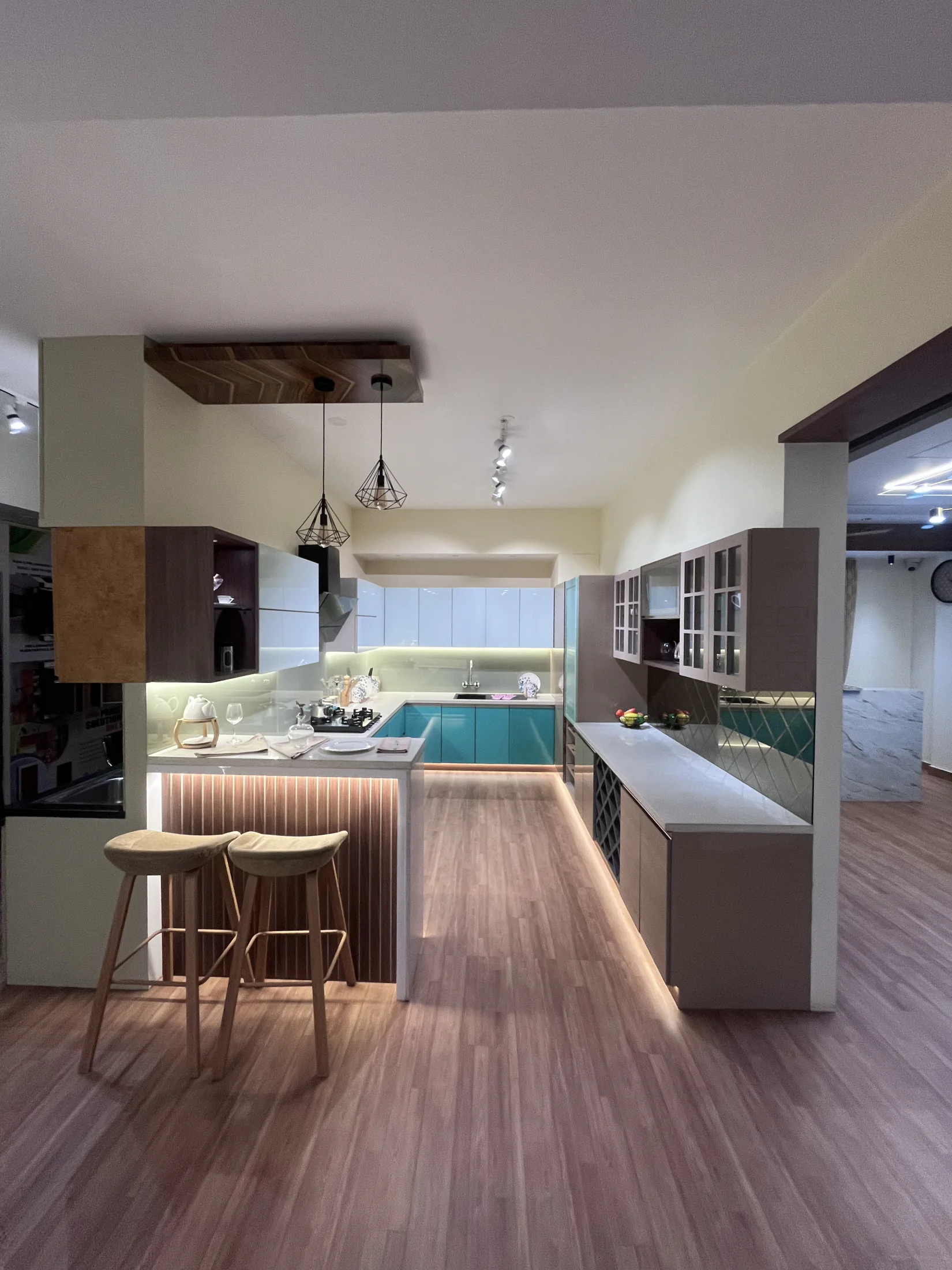 Teal kitchen peninsula and display storage by SK Spaces